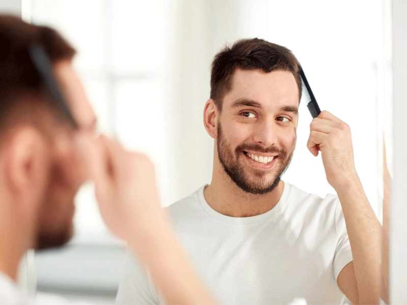 beauty-grooming-people-concept-smiling-young-man-looking-mirror-brushing-hair-with-comb-home-bathroom